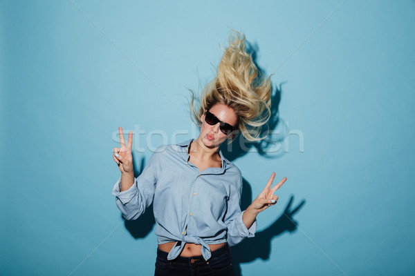 Unusual blonde woman in shirt and sunglasses showing peace gestures Stock photo © deandrobot