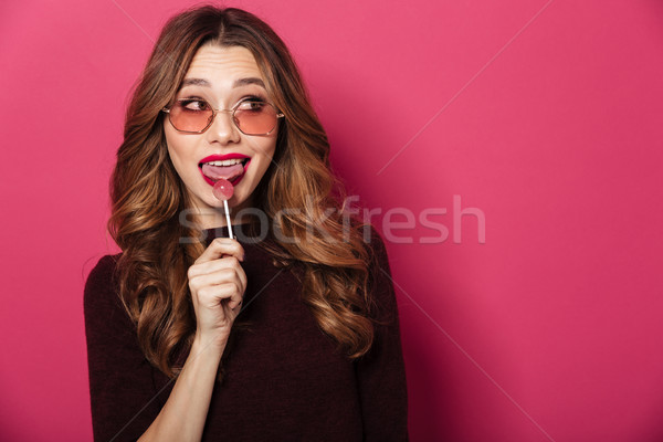 Gyönyörű hölgy visel szemüveg eszik cukorka Stock fotó © deandrobot
