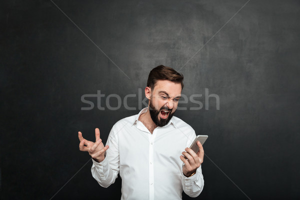 Emotional male worker screaming in anger and outrage while looki Stock photo © deandrobot