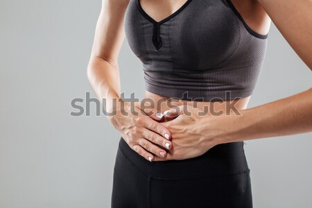 Cropped image of a sportswoman suffering from stomach pain Stock photo © deandrobot