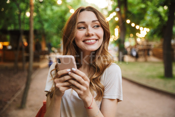 Satisfait jeune fille téléphone portable permanent parc [[stock_photo]] © deandrobot