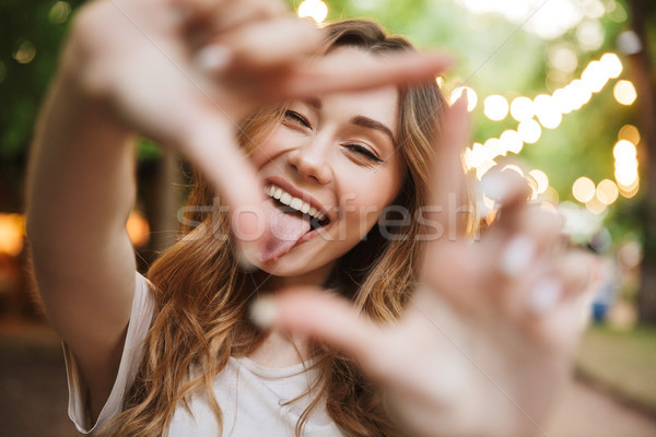 Close up of joyful young girl showing frame Stock photo © deandrobot