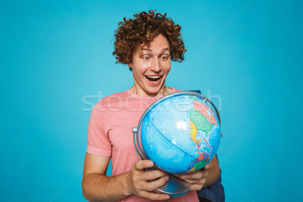 Photo of teenage guy with curly hair wearing backpack smiling an Stock photo © deandrobot