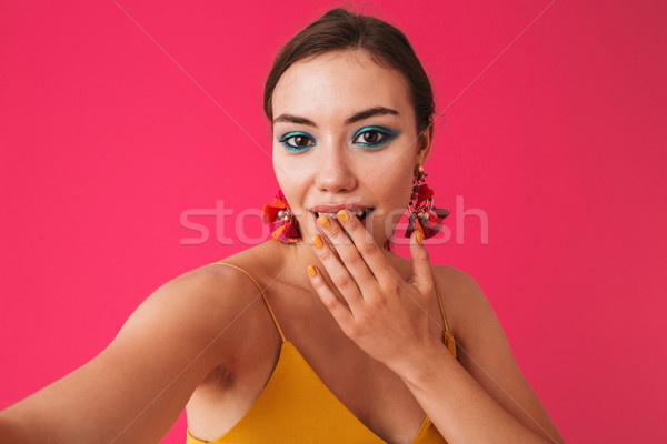 Photo of excited elegant woman 20s wearing earrings covering mou Stock photo © deandrobot
