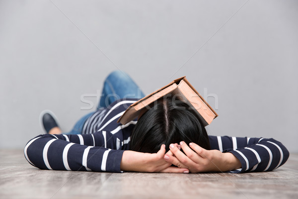 Young tired woman sleeping with book on her face Stock photo © deandrobot