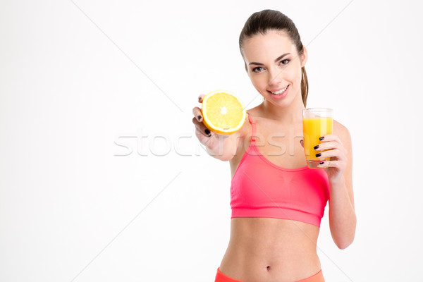 Positive attrative young sportswoman showing an orange half  Stock photo © deandrobot