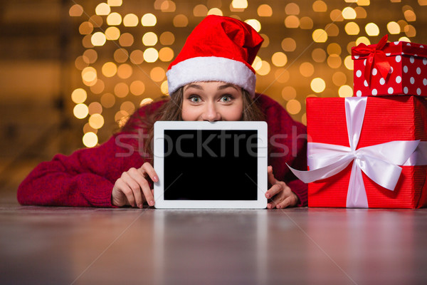 Amusing positive girl lying and hiding behind tablet blank screen   Stock photo © deandrobot