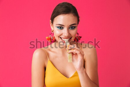 Stock photo: Beautiful tender young woman listening to music using earphones