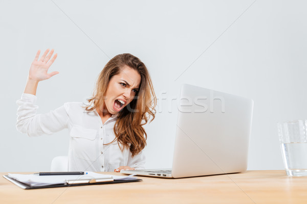 Stock photo: Angry businesswoman sitting and screaming at laptop in office