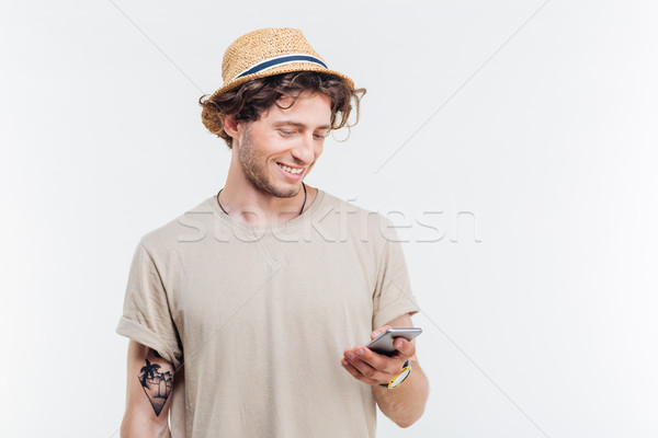 Close-up portrait of hipster man texting message using mobilephone Stock photo © deandrobot