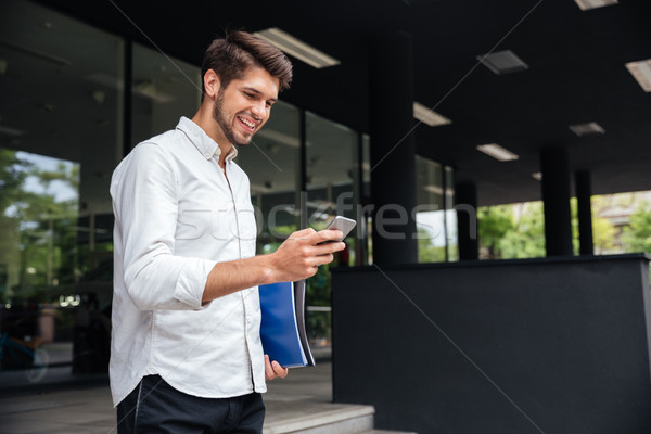 Heiter Geschäftsmann Smartphone Stadt gut aussehend jungen Stock foto © deandrobot