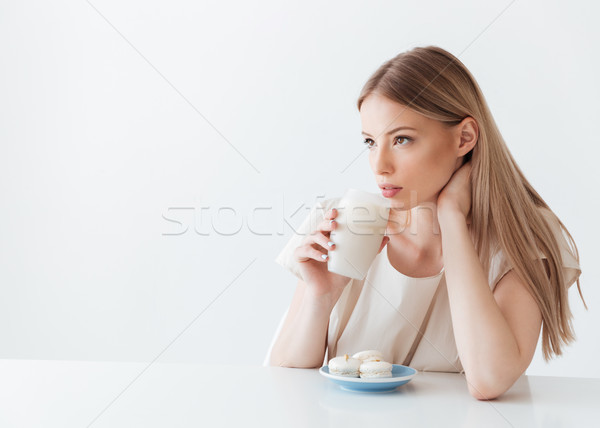 Lady sitting isolated near sweeties drinking coffee Stock photo © deandrobot