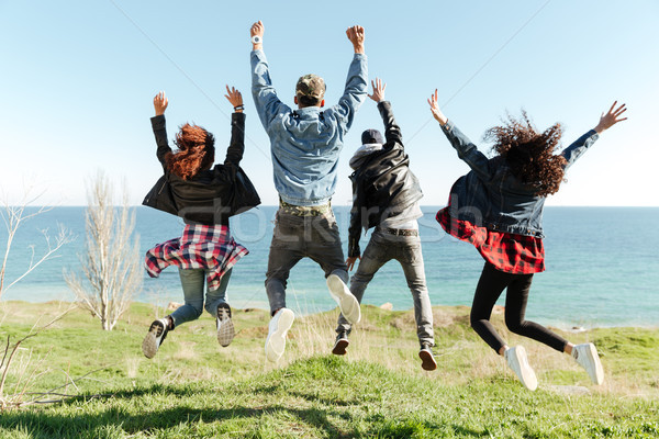 Back view picture of a group of friends jumping Stock photo © deandrobot