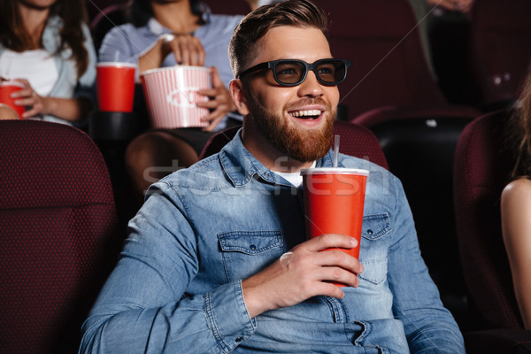 Concentrated young man sitting in cinema Stock photo © deandrobot