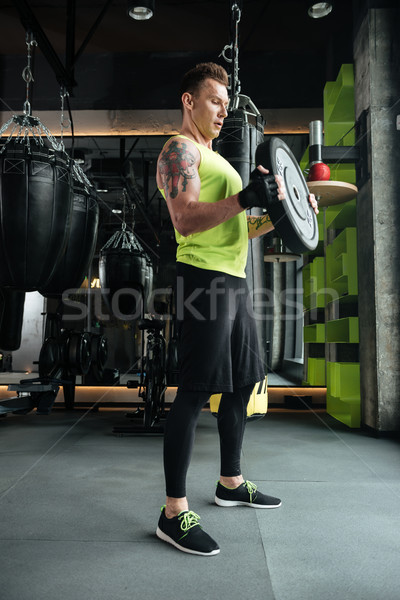 Handsome sportsman make sport exercises in gym Stock photo © deandrobot