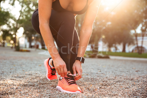 Cropped photo of strong young sports woman tie laces. Stock photo © deandrobot