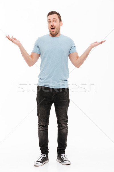 Full-length portrait of happy man with stubble in casual throwin Stock photo © deandrobot