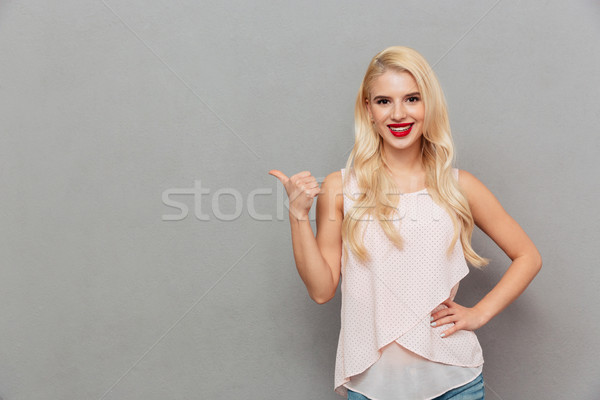 Portrait of a confident woman pointing finger Stock photo © deandrobot