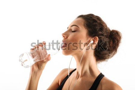 Side view image of a pretty curly brunette fitness woman Stock photo © deandrobot