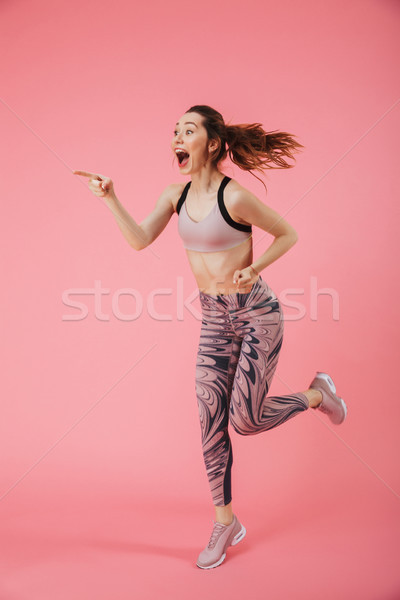 Vertical image of Surprised happy sportswoman running Stock photo © deandrobot