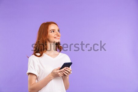 Portrait of a smiling young girl holding mobile phone Stock photo © deandrobot