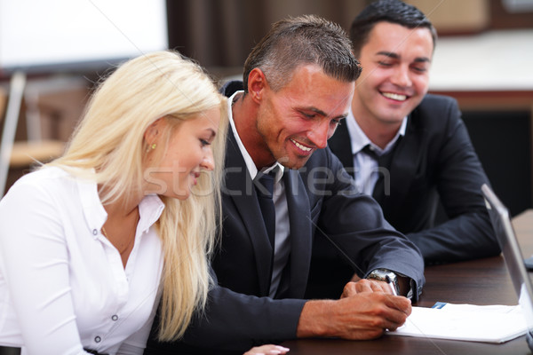 Smiling working people sitting at the business meeting in office Stock photo © deandrobot