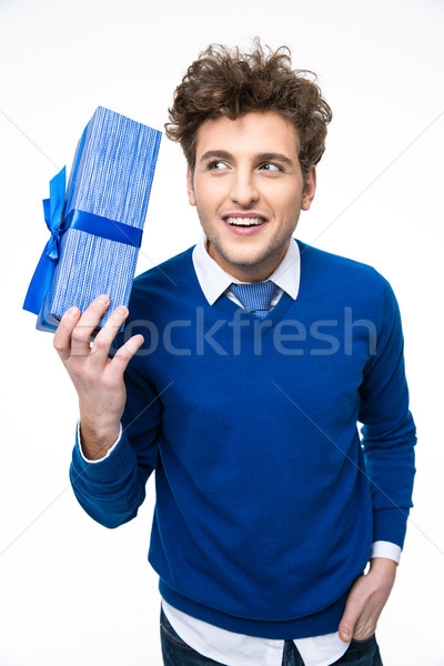 Smiling man holding gift over white background Stock photo © deandrobot