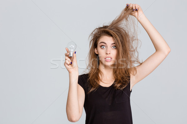 Funny woman holding bulb Stock photo © deandrobot