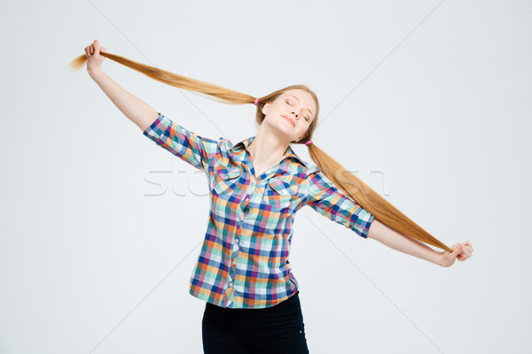 Female teenager with closed eyes holding her ponytails Stock photo © deandrobot