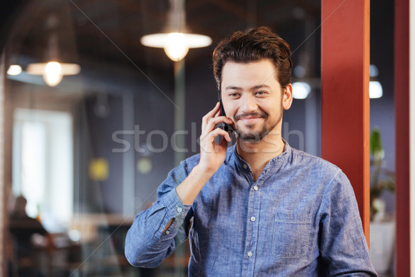 Hombre hablar teléfono oficina sonriendo feliz Foto stock © deandrobot