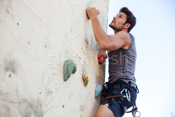 Fiatalember testmozgás hegymászás gyakorlat fal fiatal Stock fotó © deandrobot