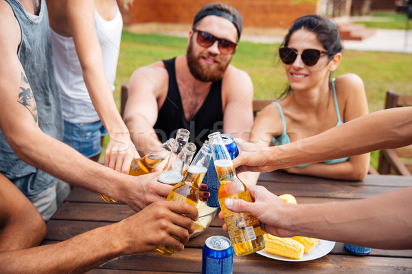 Friends celebrating and drinking beer outdoors Stock photo © deandrobot