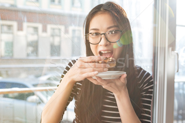 Asian kobieta jedzenie ciasto parapet okulary Zdjęcia stock © deandrobot
