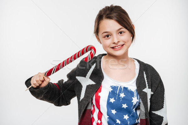 Cheerful young girl posing with candy Stock photo © deandrobot