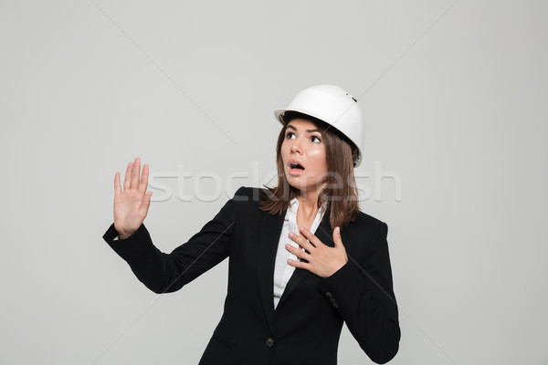 Portrait of a young scared woman in suit and hard hat Stock photo © deandrobot