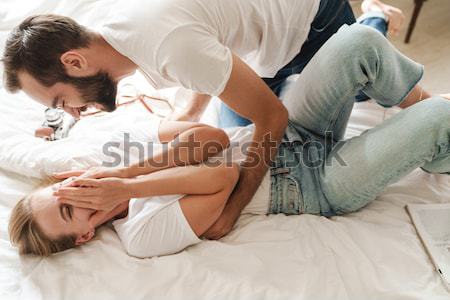 Portrait of a happy woman lying on her boyfriends lap Stock photo © deandrobot