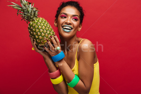 Smiling mulatto woman with fashion makeup in yellow shirt enjoyi Stock photo © deandrobot