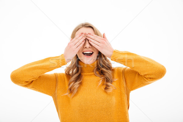 Happy young woman covering eyes with hands. Stock photo © deandrobot