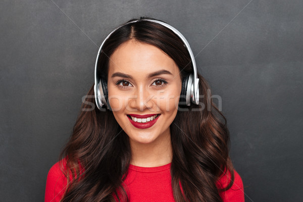 Stock photo: Close-up view of brunette woman in red blouse and headphones