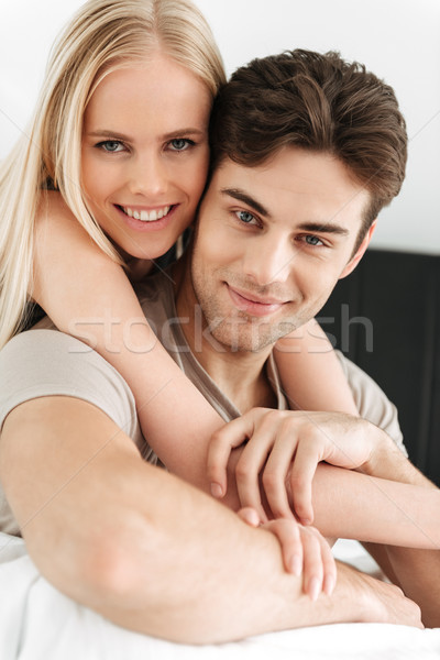 Portrait of beautiful couple looking camera in bed Stock photo © deandrobot