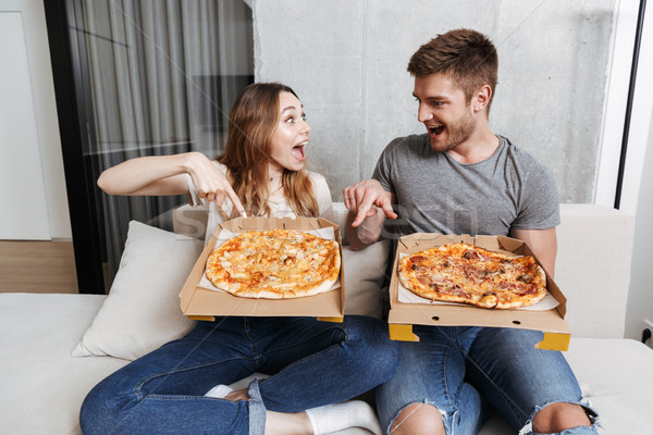 Cheerful young couple holding boxes with pizza Stock photo © deandrobot