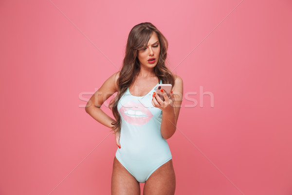 Portrait of a confused young woman dressed in swimsuit Stock photo © deandrobot