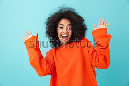 Portrait of young woman with curly hair throwing up hands, and e Stock photo © deandrobot