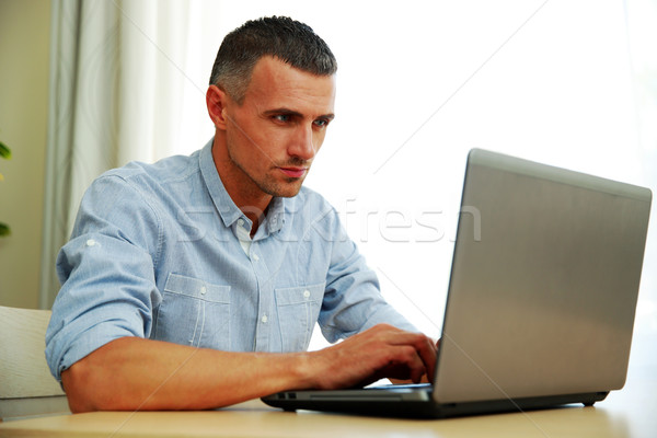 Handsome man using laptop Stock photo © deandrobot