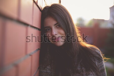 Happy cute woman leaning on the brick wall Stock photo © deandrobot