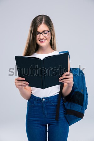 Portrait of a smiling female teenager reading book Stock photo © deandrobot