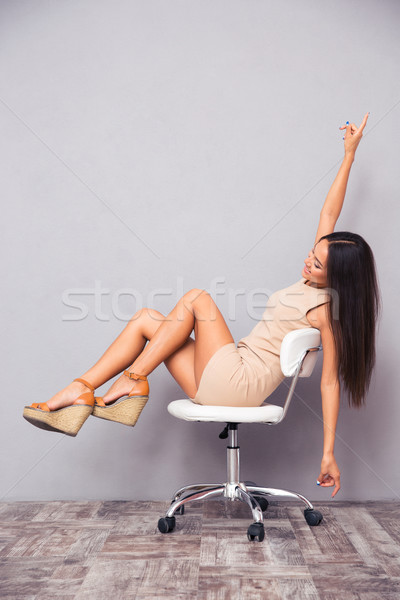 Funny young woman sitting on chair Stock photo © deandrobot