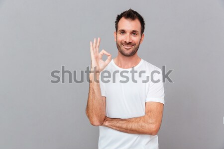 Handsome inspired male pointing away on copyspace Stock photo © deandrobot