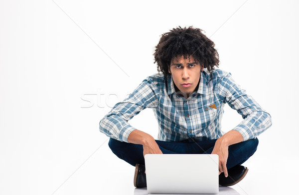 Sad afro american man sitting on the floor with laptop Stock photo © deandrobot