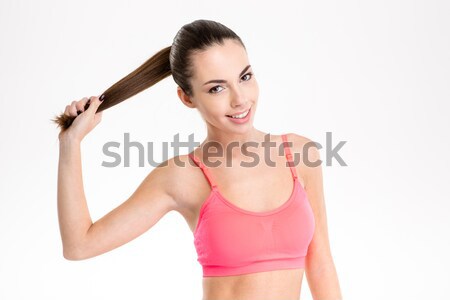 Profile of sportswoman in pink top holding up her ponytail Stock photo © deandrobot